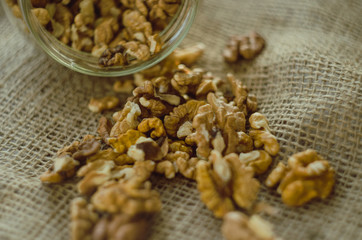 Walnuts scattered from glass jar