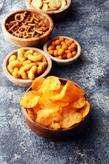 Salty snacks. Pretzels, chips, crackers in wooden bowls.