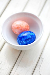  Two painted Easter eggs in white bowl