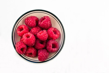 Bowl of Red Raspberries against a white background
