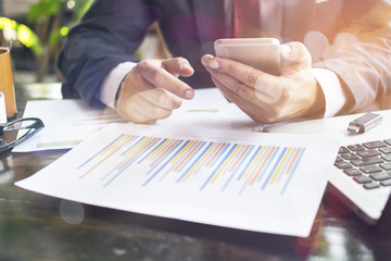 business hand working on laptop computer with financial business graph information diagram on wooden desk as concept