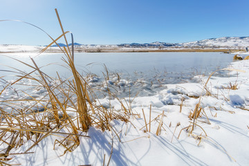 A lake in Colorado in winter with the Rocky Mountains in the background