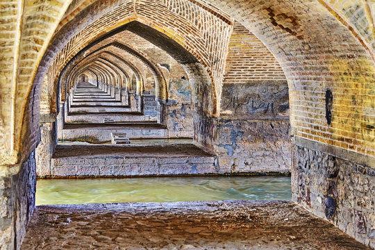 Arches made of bricks under old stone bridge, Isfahan, Iran.