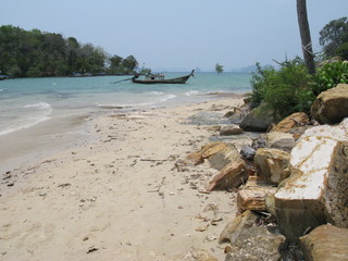 Naklejka premium krabi thailand beach with large rocks on it and a long tail boat in the water