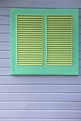 Green Louvered Window on Gray Wooden Panel Wall