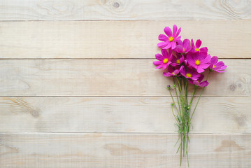 top view of bouquet of cosmos flower on wooden table with copy space
