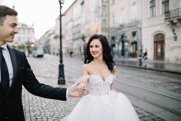 Fototapeta premium Portrait of a romantic beautiful couple traveler walking in the street in summer in old city.