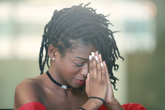 Black female praying with closed eyes