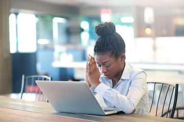 Black female praying while working