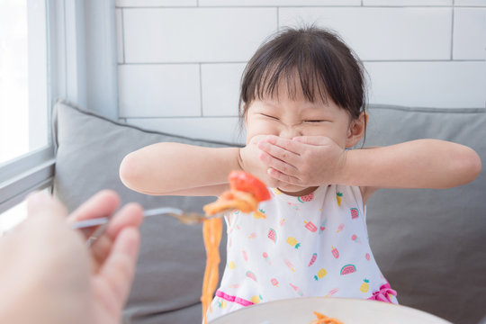 Little asian girl refuse toeat tomato in spagethi from her mother