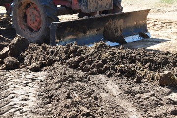 tractor push clot soil after pour from truck