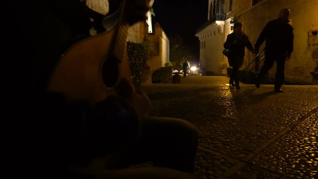 The musician with guitar on medieval street of Palma de Mallorca at the night