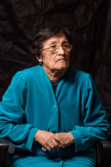 portrait of an elderly thoughtful woman on a dark background