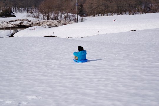 日本のスキー場でそり遊びをする子供