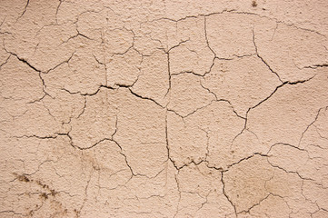 cracked plaster of beige similar to the cracked earth in the desert