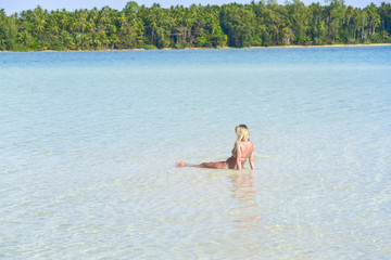 A lady tourist rest on the shallow water to rest from swimming at KojKham Island,Trad,Thailand