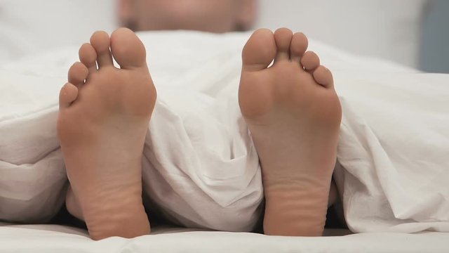 Adult man sleeping feet moving close up, health body care, vacation lifestyle
