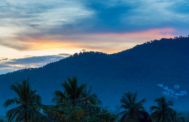 Fototapeta na wymiar Spectacular sunset over the jungle and mountains on a tropical island 
