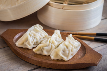 Steamed dumplings on wooden plate.