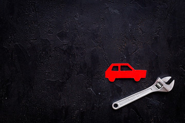 Car failures. Car service concept. Car silhouette, wrench on black backgound top view copy space