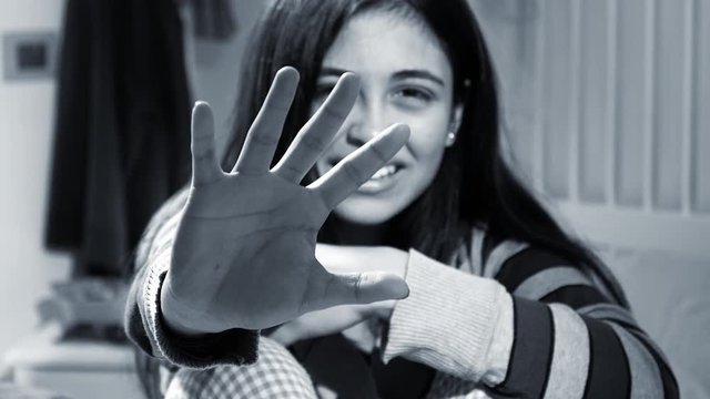 woman scared about domestic violence closeup of hand in front of face blak and white