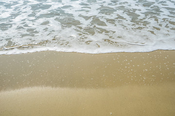 Soft wave of blue ocean on sandy beach. Background.