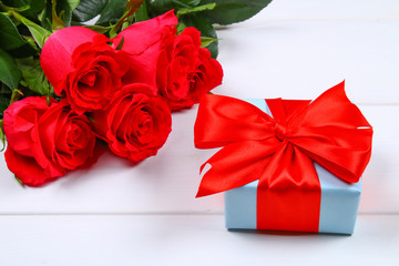 Pink roses with a gift box tied with a bow. Template for March 8, Mother's Day, Valentine's Day.
