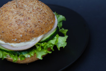 Big sandwich - Homemade Hamburger with juicy Chicken Meat, Cheese, Tomato, and Onion on Black background