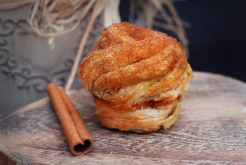 Homemade Baked Rolls or Buns with Cinnamon Powder, rustic wooden background. Bakery concept. Sweet cinnamon rolls as dessert. Close-up