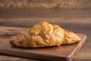 Croissant Placed on a Wooden Cutting Board after leaving the oven.