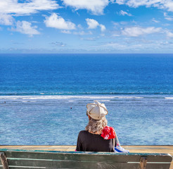 femme assise sur banc contemplant l'océan