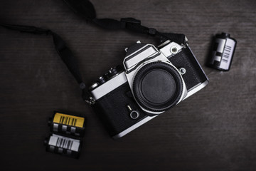 Vintage camera and film on wood background. 