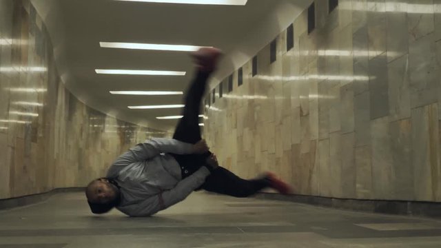 Black man dancing hip-hop in an underground crossing