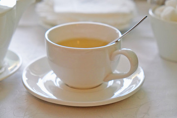 tea in a white mug on the table in a cafe