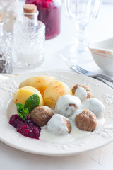 Meatballs with cream sauce and cranberry jam, on a white plate, selective focus