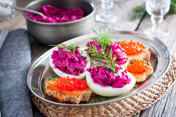 Stuffed eggs with beets and salted fish, horizontal