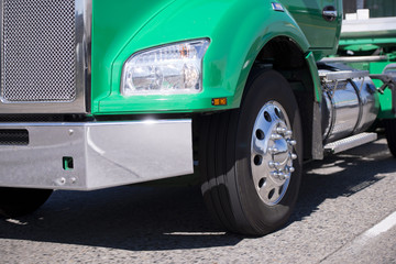 Part of powerful green big rig semi truck with chrome grille