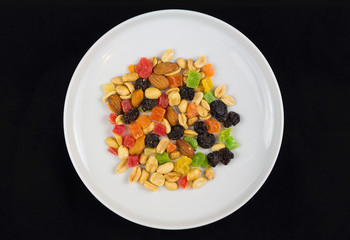 Dried fruits and nuts on white plate, proper nutrition