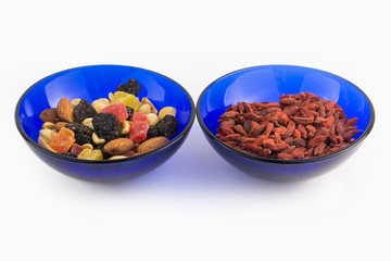 Dried fruits, nuts and goji berries in two bowl on white background