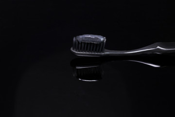 black toothbrush and black toothpaste on a black background