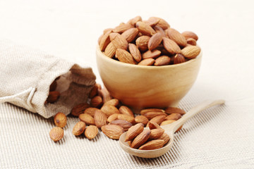 almonds nuts in a wooden spoon over corrugated paper
