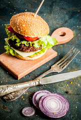 Fast food. Unhealthy food. Delicious Fresh Tasty Burgers with Beef Cutlet, fresh Vegetables and Cheese on dark blue concrete background. Copy space