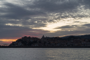 Naklejka premium Stormy clouds of contrasting color over the evening city