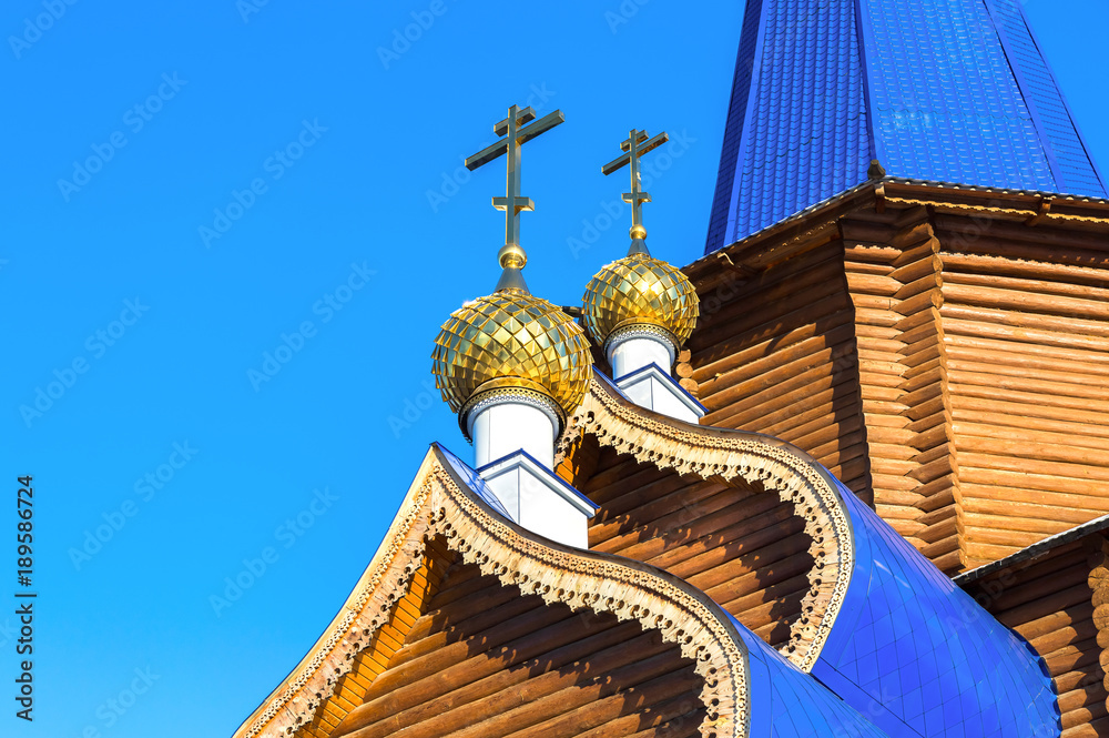 Sticker Golden domes with crosses on wooden orthodox church against the blue sky in Samara, Russia