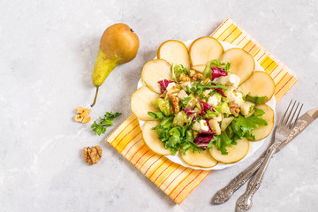 Salad with pears, feta cheese, salad mix and walnuts