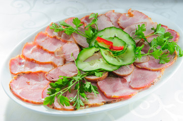 Slised meat meal with vegetables on white plate.