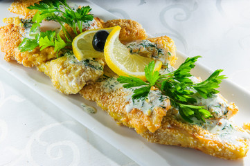 Fish dish - fried fish fillet with vegetables on white background