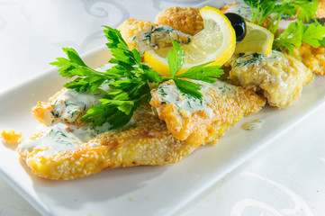 Fish dish - fried fish fillet with vegetables on white background