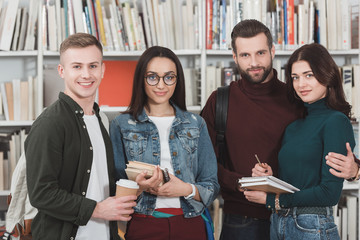 four multicultural students looking at camera in library