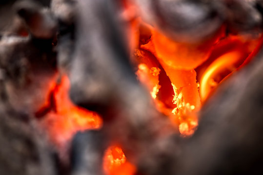 Fototapeta Ignite the fire. Warming up the cold winter nights. A macro shot of firewood, white dust and hot, glowing coal. Burning branches and wood. Flames in the fireplace, cozy home, warmth, love, romantic